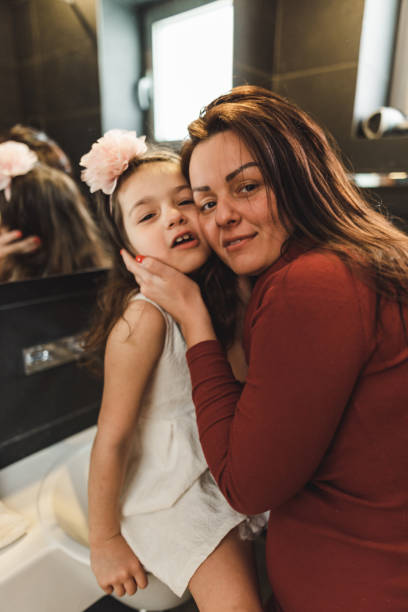 istock mother dressing up the daughter in the bathroom 2201015228