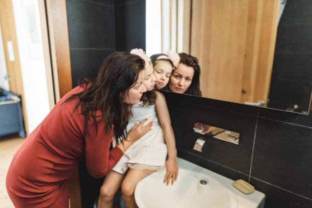 istock mother dressing up the daughter in the bathroom 2201015290