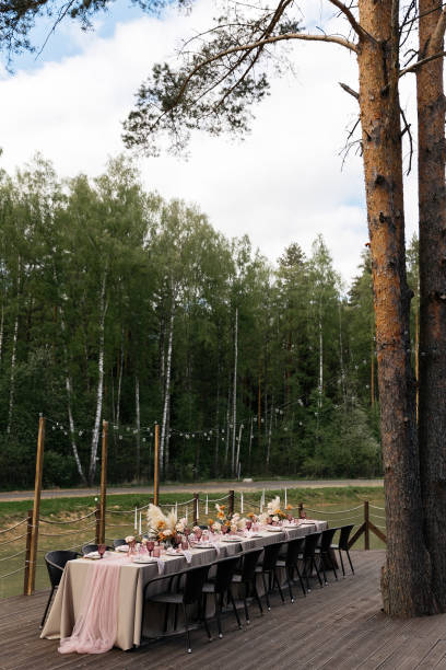 istock Long elegant dining tables set in an outdoor orchard. 2201015443