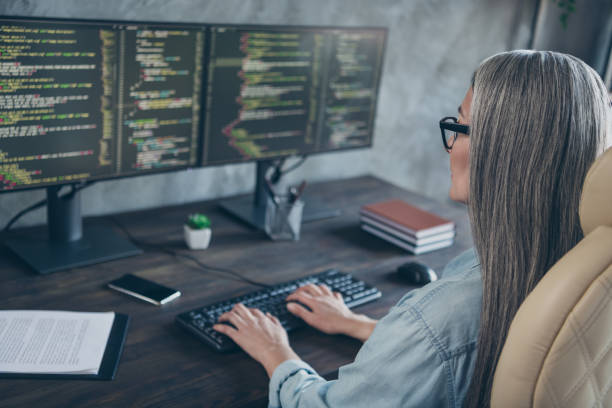 istock Photo of smart focused retired pensioner lady typing keyboard solving error webpage sit desk in workspace 2201021711