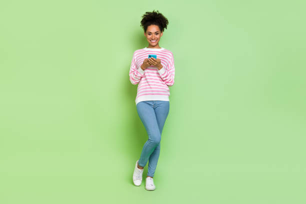 istock Photo of pretty shiny lady dressed pink pullover typing modern device isolated green color background 2201022072