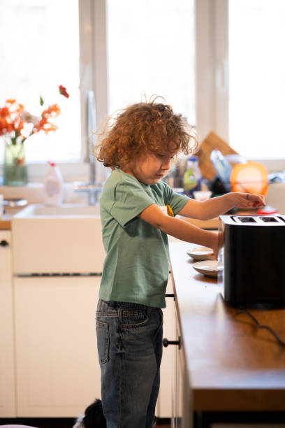 istock Little boy in the kitchen preparing a meal by himself 2201024850