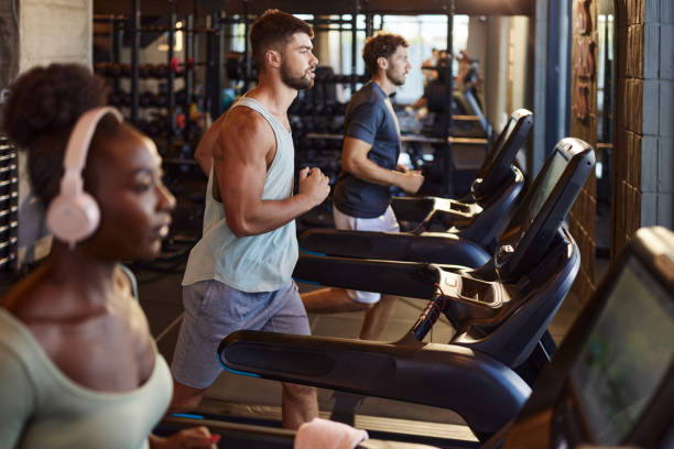 istock Group of athletic people running on treadmills in a gym. 2201024912
