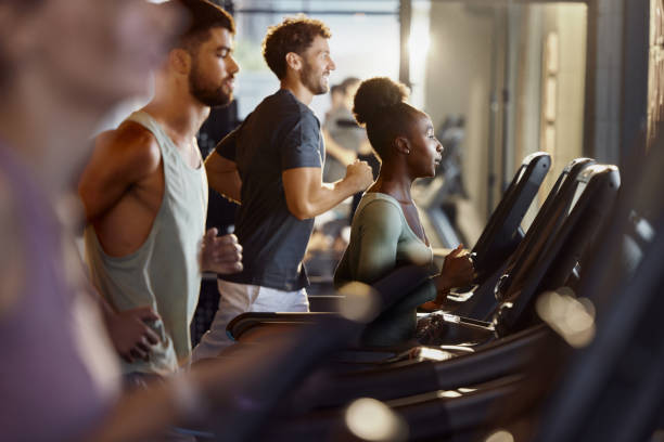 Determined black sportswoman running on treadmill in a gym.