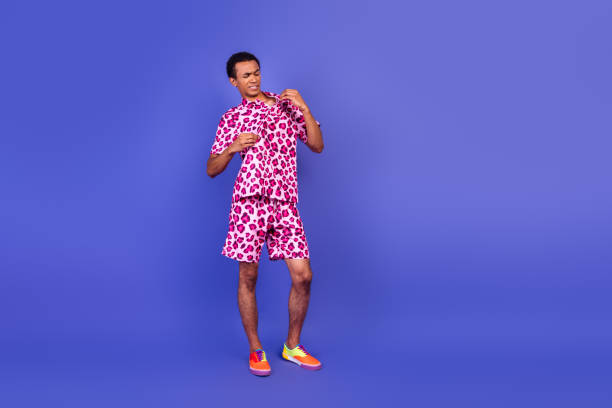 istock Stylish young man in vibrant attire with leopard print design against a purple backdrop 2201025645