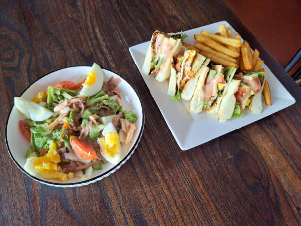 Delicious Chicken Salad With Chicken Meat, Boiled Eggs And Fresh Vegetables. Chicken Sandwich With Chicken Meat, White Bread, Vegetables And French Fries. Food Menu.