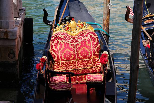Gondola boat ornamented velvet seat on a canal in Venice, Italy.