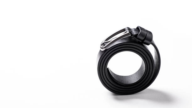 istock Twisted black leather belt with matted metal buckle isolated on white background. Fastened fashionable unisex, man or woman accessory for trousers, jeans, dress. Male luxury strap. Haberdashery goods 2201030081