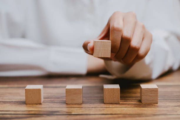istock Hand Holding Wooden Block Above Empty Space on Wooden Table 2201031147
