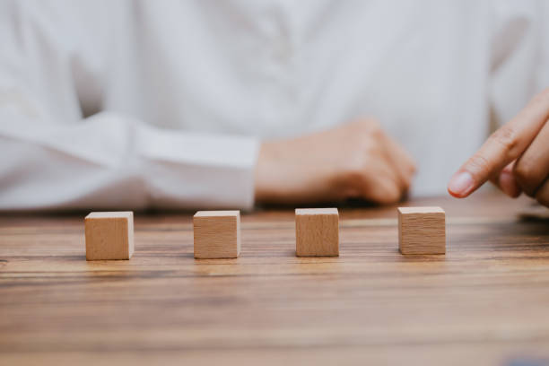 istock Wooden Blocks Arrangement with Hand Gesturing on a Table Surface 2201031160