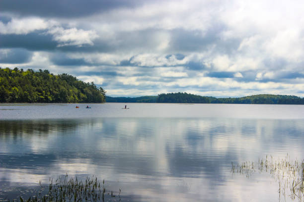 A few kayakers on a sunny day in August at Kejimkujik Lake, by Jeremys Bay Campground in Kejimkujik National Park and National Historic Sight, Nova Scotia