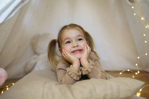 istock Adorable little girl lying in tent 2201031540