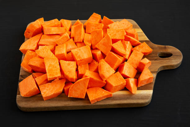 istock Raw Chopped Sweet Potatoes on a Cutting Board, side view. 2201033553