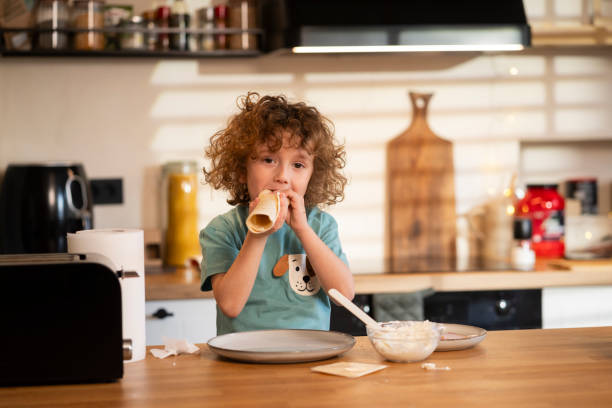 istock Little boy in the kitchen preparing a meal by himself 2201034692