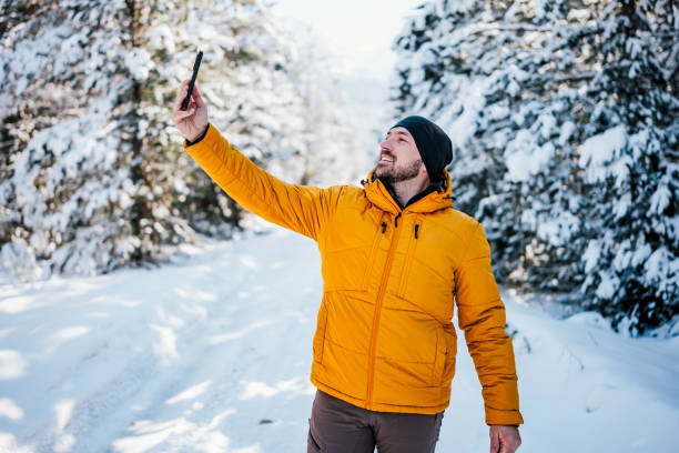 istock Portrait of  smiling young man in winter forest 2201035134