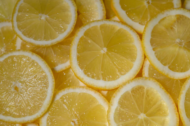 istock Fresh lemon slices arranged artistically on a bright background, showcasing their vibrant color and texture 2201036215