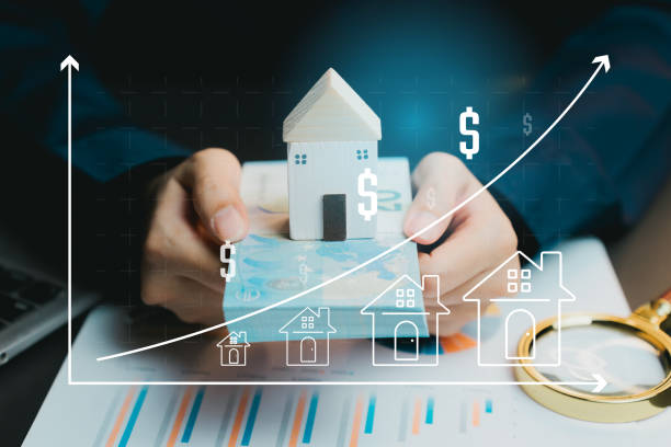 istock Hands Holding Wooden House Model With Money and Growth Graph 2201038930