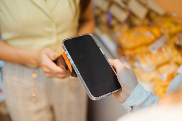 istock Close up of Asian woman making a mobile payment. 2201042668
