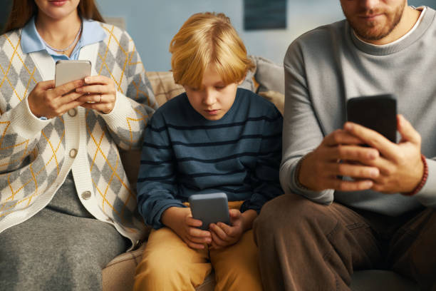 istock Family Using Smartphones While Sitting on Couch at Home 2201045093