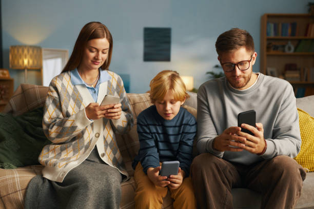istock Family Bonding Over Smartphone Devices on Cozy Couch 2201045108