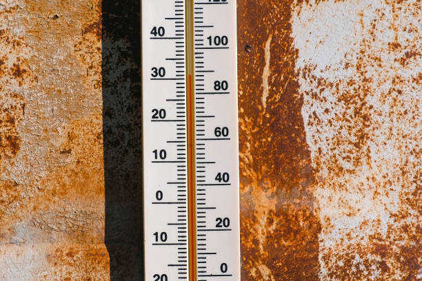Thermometer on a rusty wall which shows 30 degrees of heat