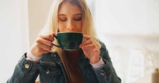 istock Woman, smell and drink with coffee cup at cafe for reflection, thinking or eyes closed with scent in morning. Person, girl and relax with mug, tea or latte with memory, aroma and flavor at restaurant 2201045513