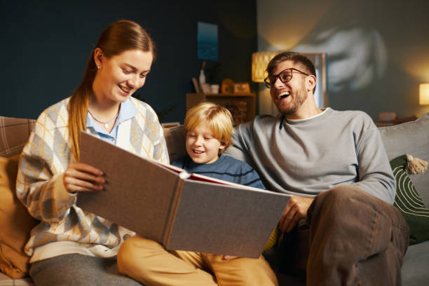 istock Family Enjoying Evening Reading on Comfortable Couch 2201046704