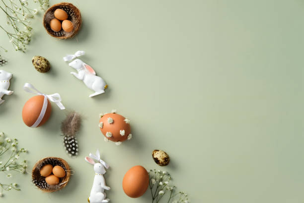 istock Happy Easter concept. Flat lay composition with decorated Easter eggs, gypsophila flowers, Easter bunny on pastel green background 2201049185
