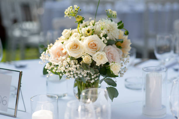 istock Elegant floral centerpiece adorning a beautifully arranged wedding reception table under soft evening light 2201050114