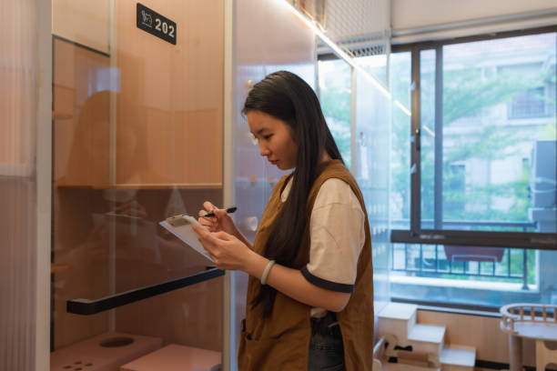 istock Cat boarding dormitory, female staff is registering cat information 2201051236