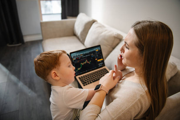 istock Selling ether, bitcoin or altcoin. Work cryptocurrency market chart on laptop monitor screen. Kid make noise and disturb woman working talking on phone. Mom work on laptop from home with child. 2201051380