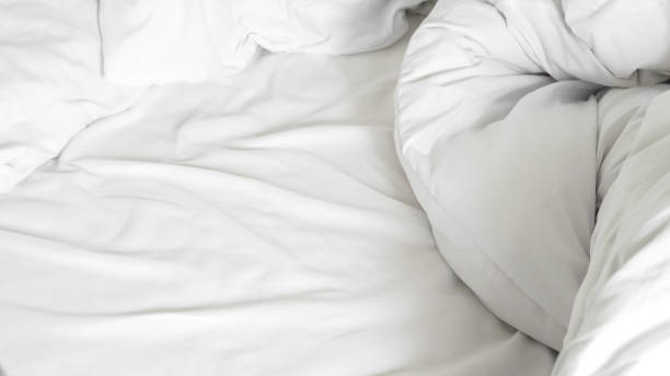 istock White soft bed linen with a clean duvet, creating a cozy background 2201051571