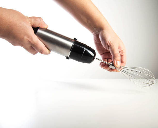 istock Modern immersion blender with whisk in hand on white background, close-up 2201053768