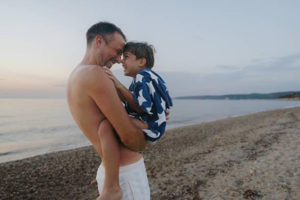 Photo of father and his son, enjoying the beach in sunset