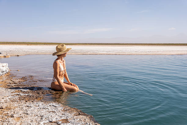 istock Woman in Sun Hat Meditating by Tranquil Lakeshore 2201055808