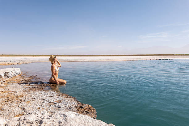 istock Woman in Sun Hat Meditating by Tranquil Lakeshore 2201055813