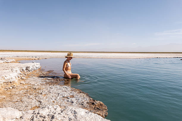 istock Woman in Sun Hat Meditating by Tranquil Lakeshore 2201055829