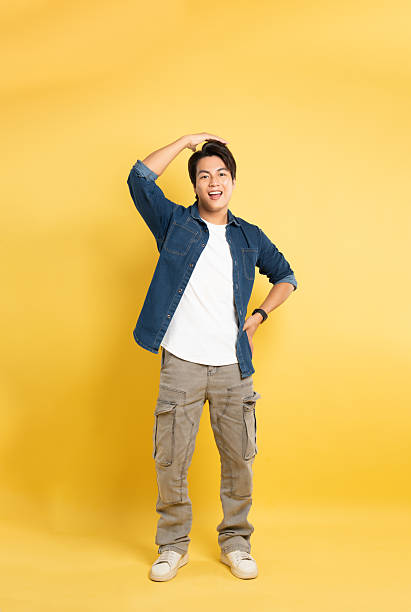 istock Portrait of asian man posing on yellow background 2201059649