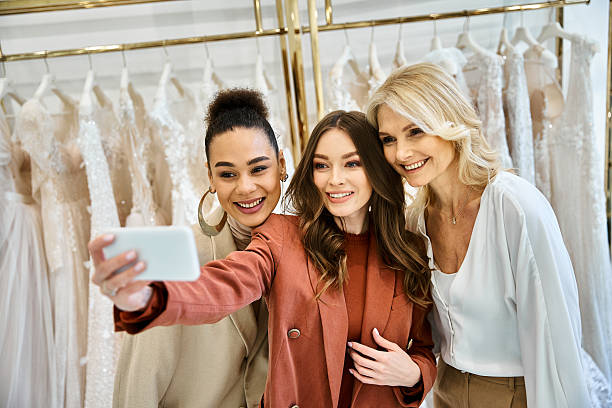 Three friends capturing joyful moments while shopping for dresses in a chic boutique
