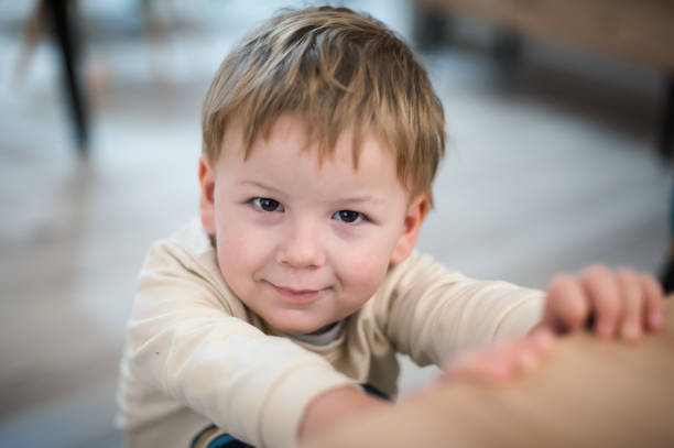 Happy boy clapping hands in a white t-shirt against a white background. Studio portrait of a cheerful child. Joyful emotions and playful mood concept. Kid aged three (three-year-old )