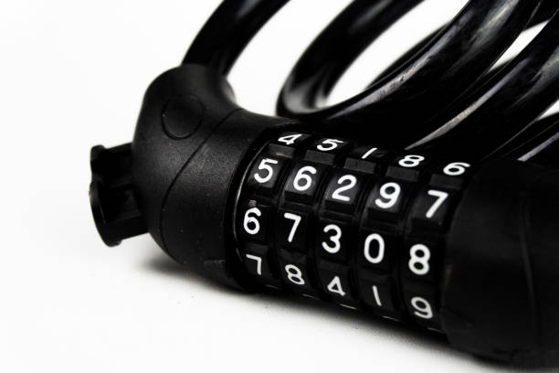 Macro shot of a black combination lock, with visible number dials, against a plain white backdrop.