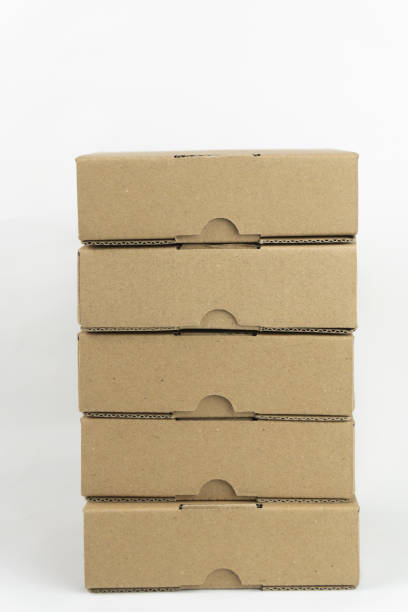 istock A stack of brown cardboard boxes, neatly arranged and ready for shipping or storage against a plain white background. 2201066945