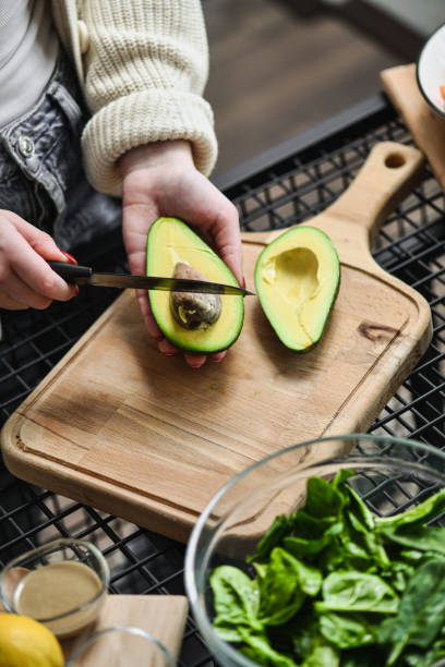 istock Avocado Seed Removal With Kitchen Knife on Wooden Cutting Board 2201068715