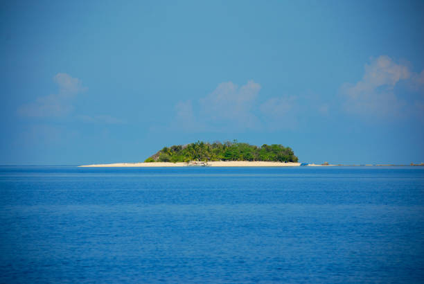 Little tropic island is on middle of the ocean with clear blue sky background.\nPhuket Island - Thailand.