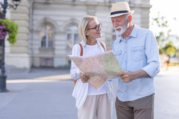 istock Senior couple standing in front of historic building with a map 2201073881