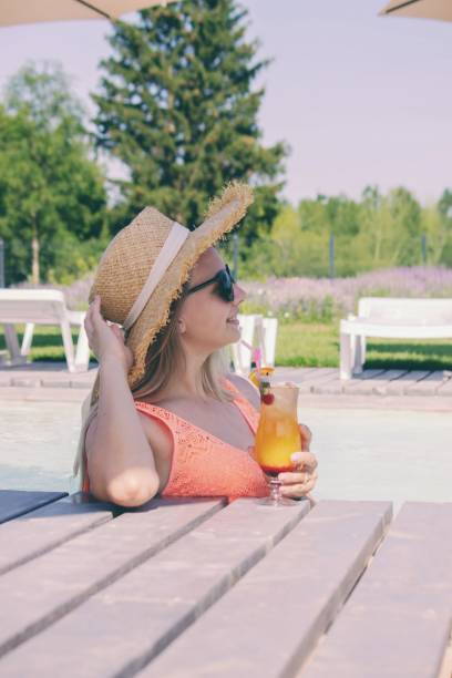 istock Woman with cocktail near the pool. 2201079267