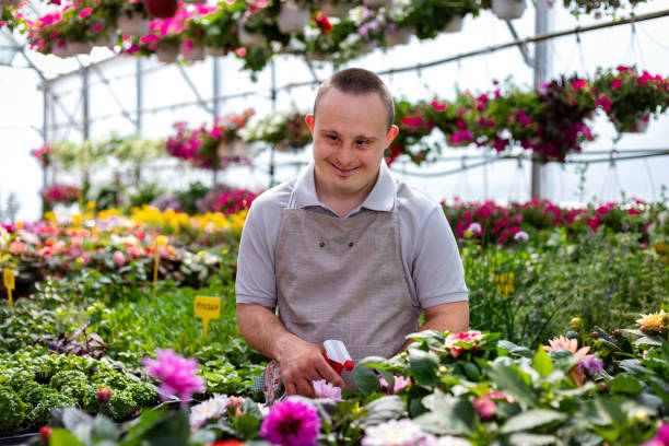 istock Young Man with Down Syndrome Working at a Garden Center 2201086105