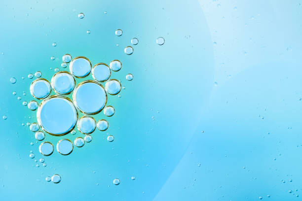 istock Transparent blue water bubbles rising in a light blue liquid background. cosmetics product backdrop 2201088262