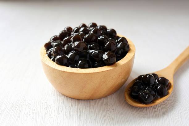 istock Black pearls for bubble mllk tea in a wooden bowl on white background 2201088874