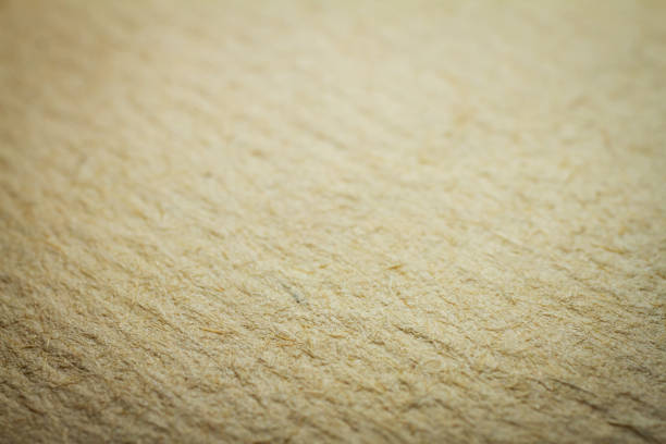 Extreme closeup of beige handmade paper with shallow depth of field.